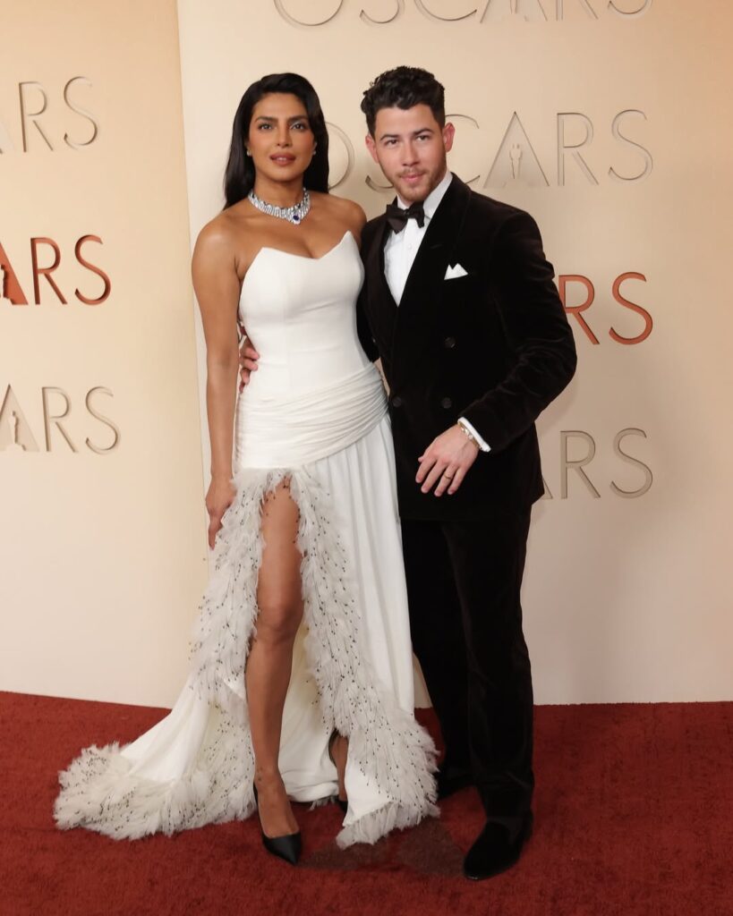 Oscars 2026 में प्रियंका चोपड़ा ने सफेद Dior गाउन पहनकर रेड कार्पेट पर सबका ध्यान खींचा। जानें उनके स्टाइल और लुक की पूरी जानकारी।